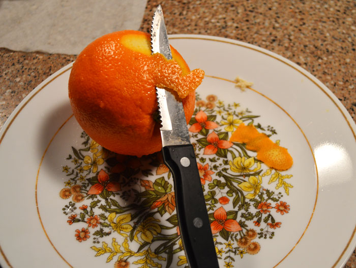peeling orange with knife