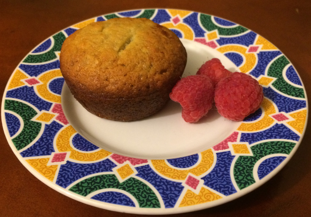 vegan banana bread muffin on plate with raspberries