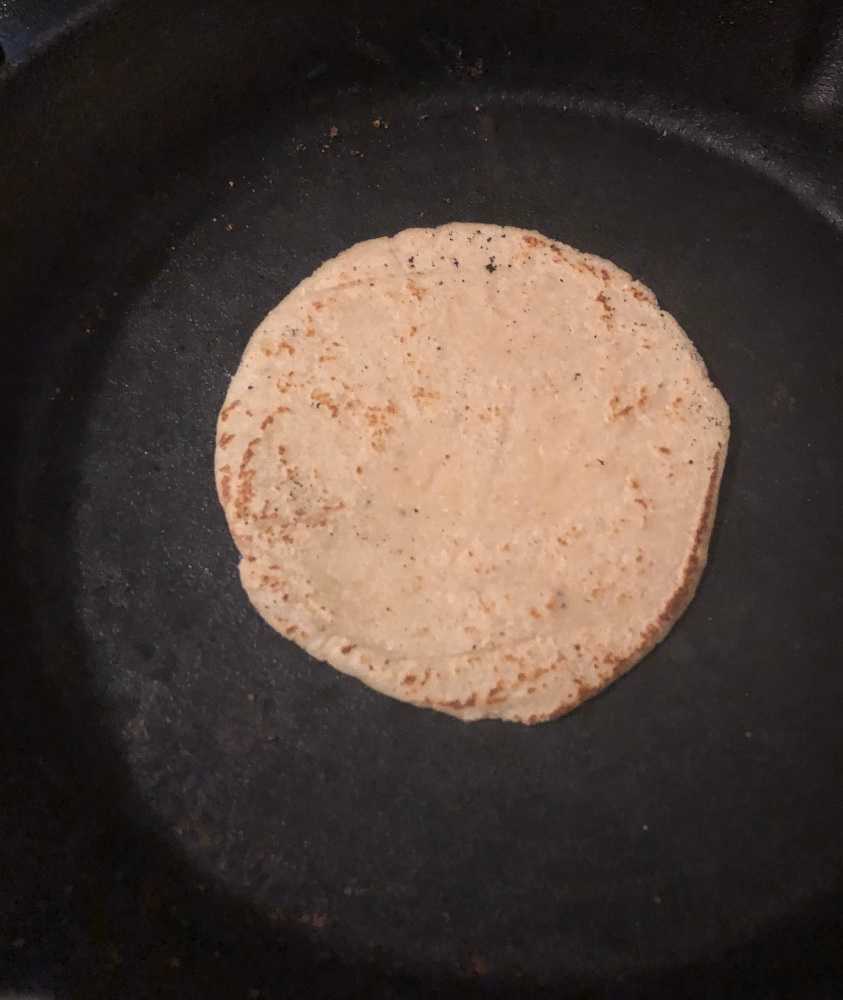 corn tortilla cooking in frying pan