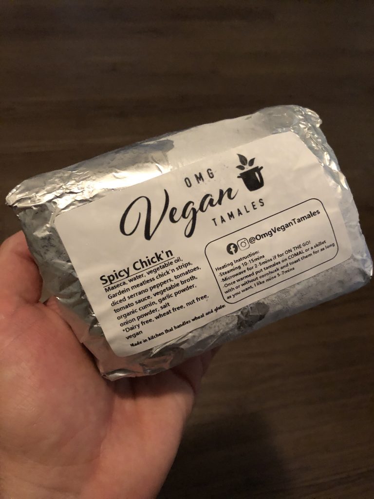 hand holding foil-wrapped package of food