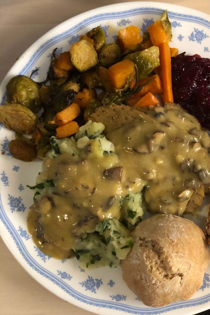 seitan roast with vegetables, mashed potatoes with kale, mushroom gravy, sourdough rolls, cranberry sauce