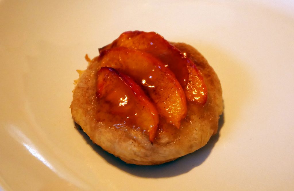 sliced glazed peaches atop a biscuit