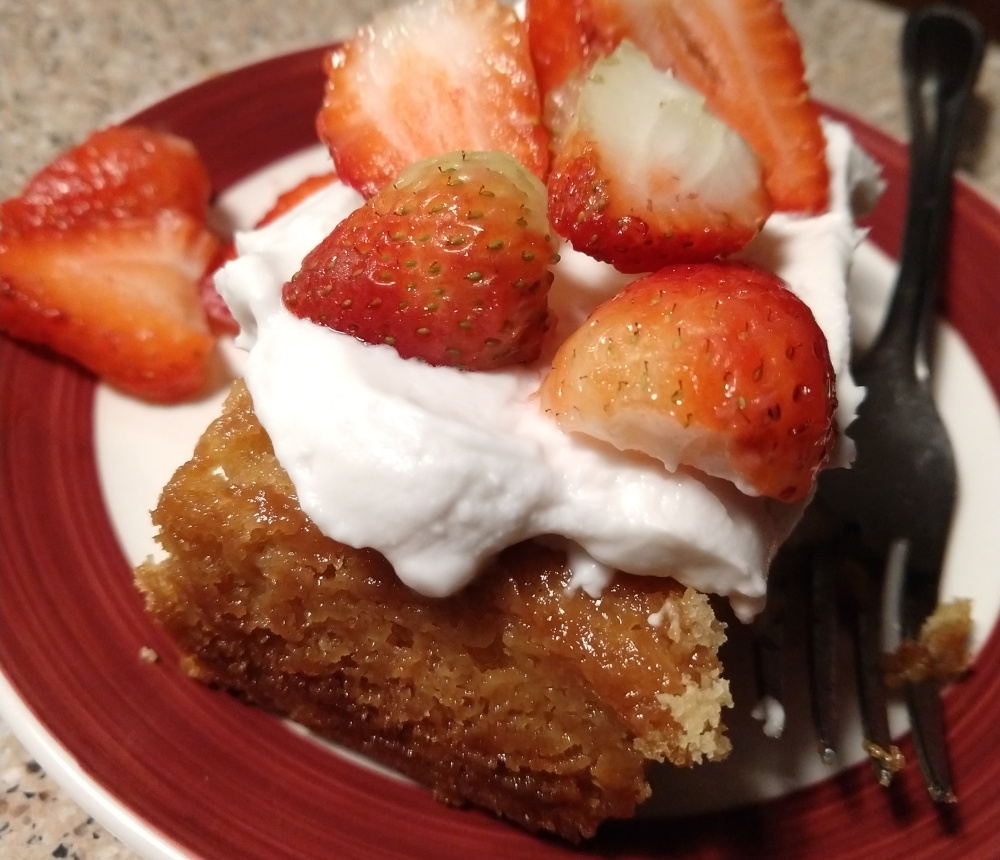 vegan orange cake with coconut whipped cream and sliced strawberries